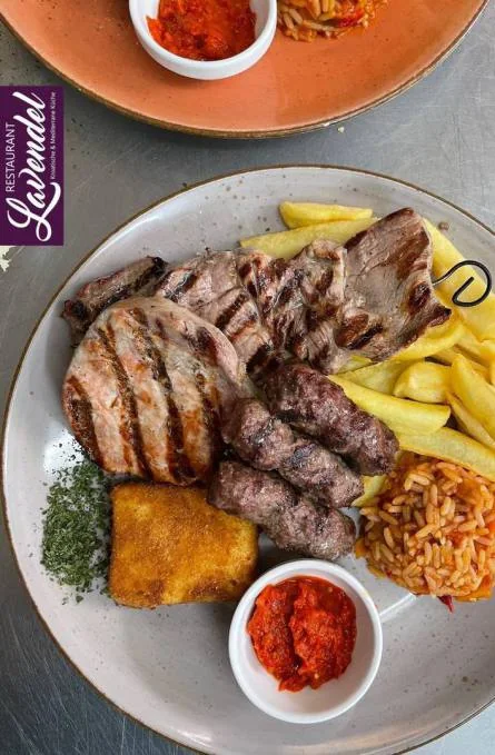 Kroatische Grillplatte mit gegrilltem Fleisch und Beilagen